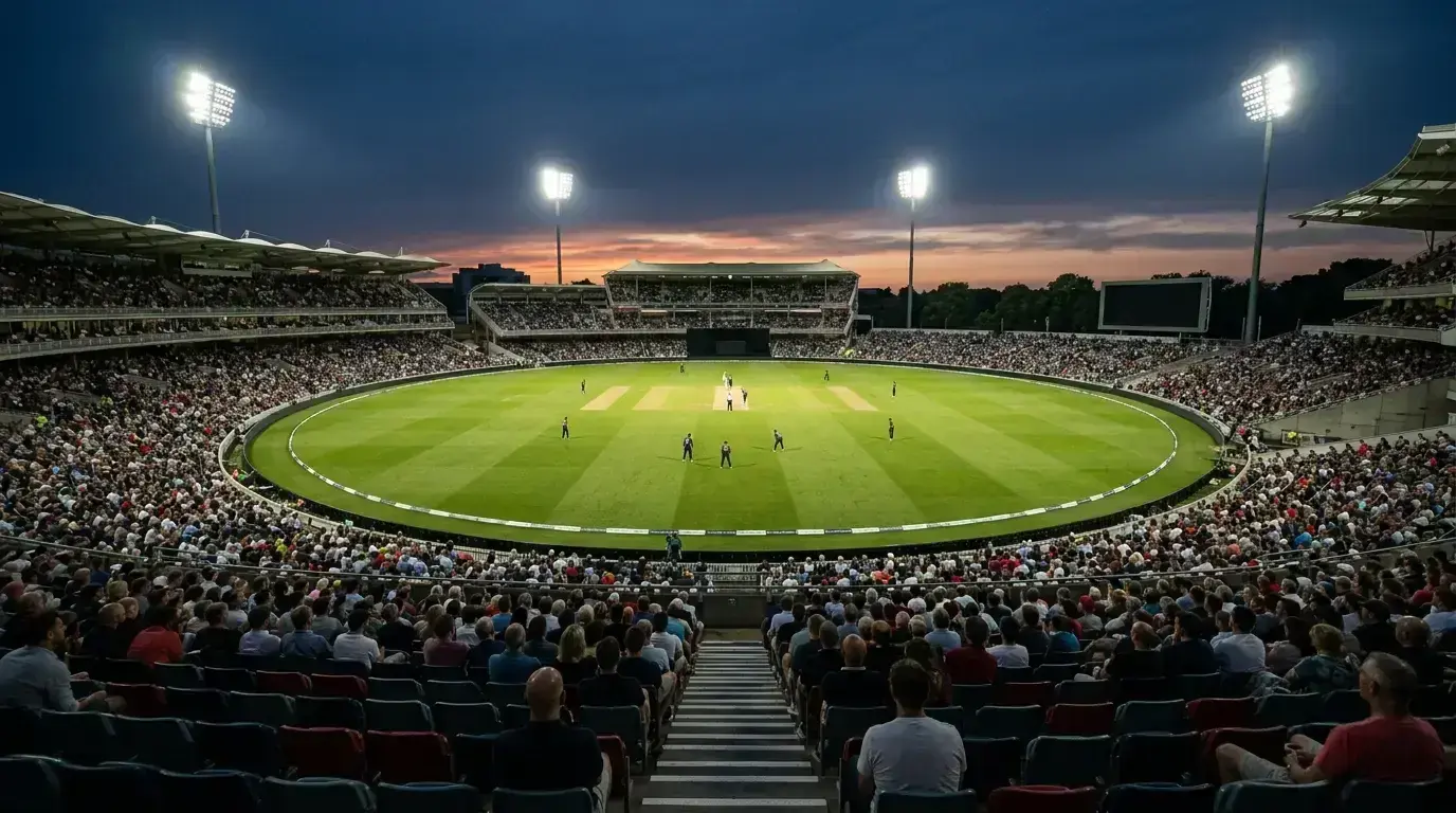 UK cricket ground at dusk with floodlights and packed stands during a match